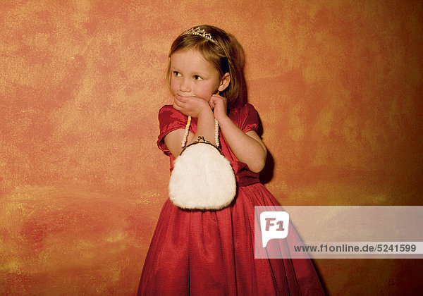 Kleines Mädchen mit rotem Kleid und weißem Täschchen