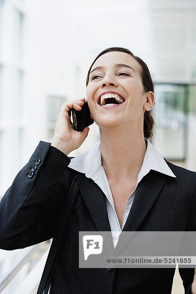 Diessen am Ammersee  Junge Geschäftsfrau beim Telefonieren  lachend