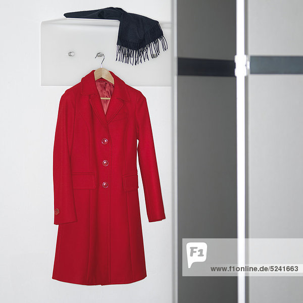 Roter Mantel hängt an Garderobe