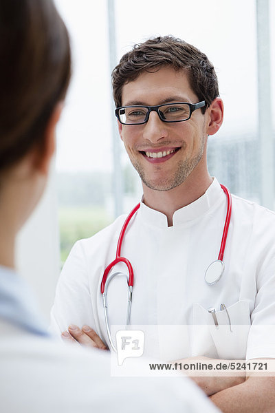 Germany  Bavaria  Diessen am Ammersee  Two young doctors with stethoscope standing face to face  smiling