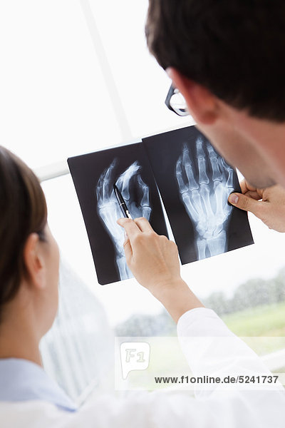 Germany  Bavaria  Diessen am Ammersee  Two young doctors examining x-ray  smiling