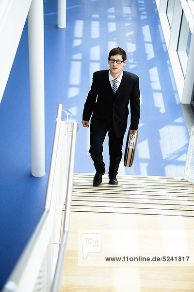 Germany  Bavaria  Diessen am Ammersee  Businesssman walking on staircase with briefcase  portrait