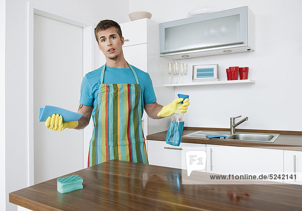 Mann putzt Küche