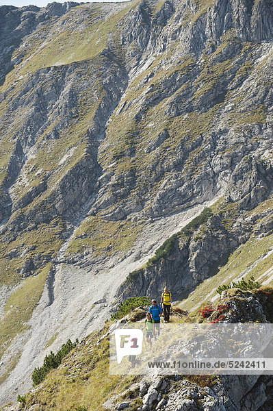 Austria  Kleinwalsertal  Group of people hiking on rocky mountain trail