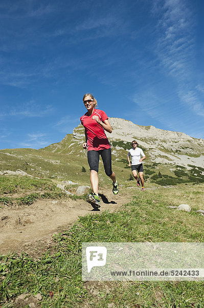 Austria  Kleinwalsertal  Man and woman running on mountain trail