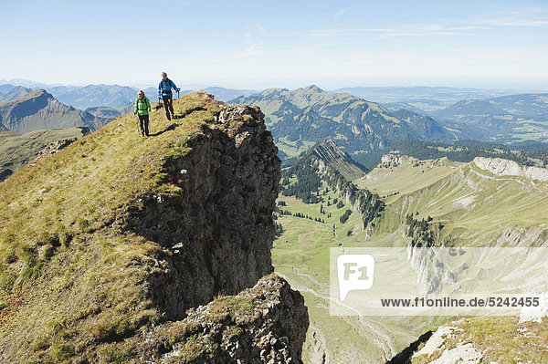 Österreich  Kleinwalsertal  Mann und Frau beim Wandern am Felsrand