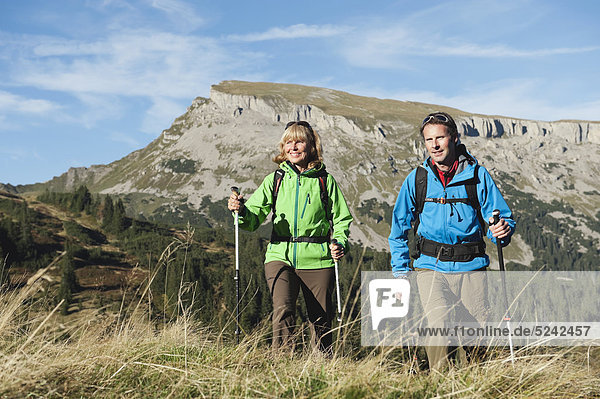 Austria  Kleinwalsertal  Man and woman hiking on mountain trail  smiling