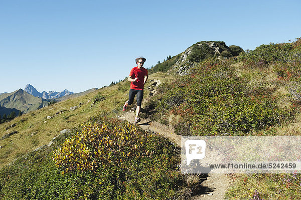 Austria  Kleinwalsertal  Mid adult man running on mountain trail