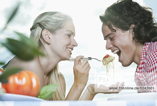 Italien  Toskana  Junge Frau füttert Spaghetti an den Mann