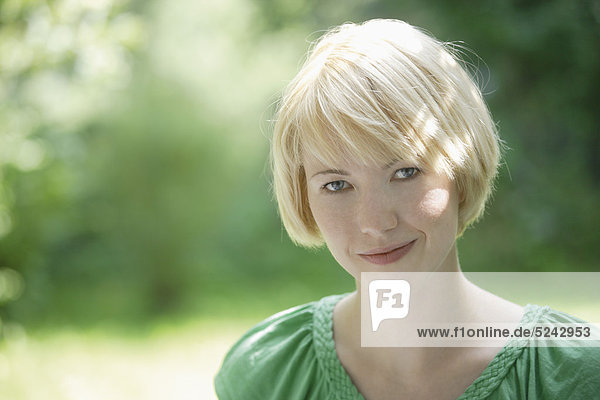Nahaufnahme einer jungen Frau im Park  Portrait  Lächeln