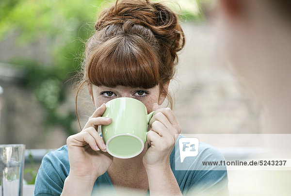 Close up of young woman drinking coffee