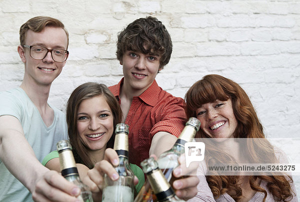 Junge Männer und Frauen mit Bierflaschen  lächelnd  Portrait
