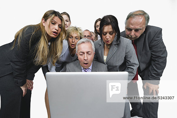 Geschäftsleute betrachten Laptop vor weißem Hintergrund
