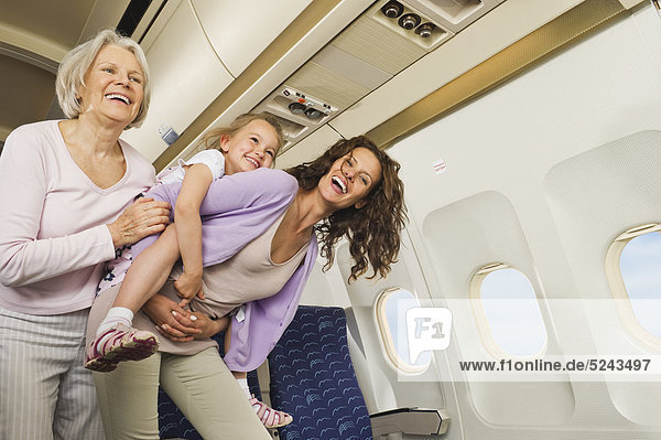 Women and girl having fun in economy class airliner