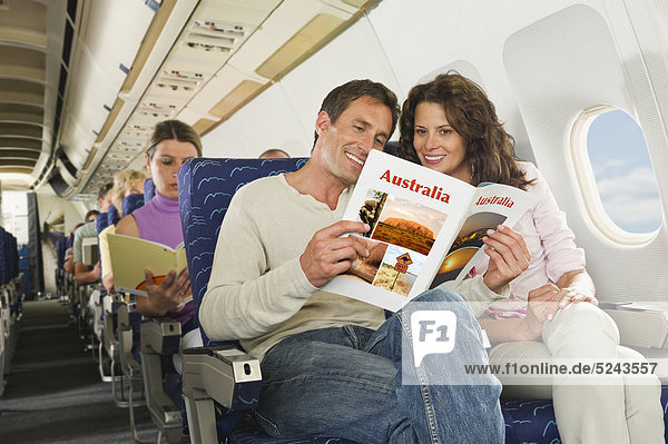Germany  Munich  Bavaria  Passengers reading book in economy class airliner