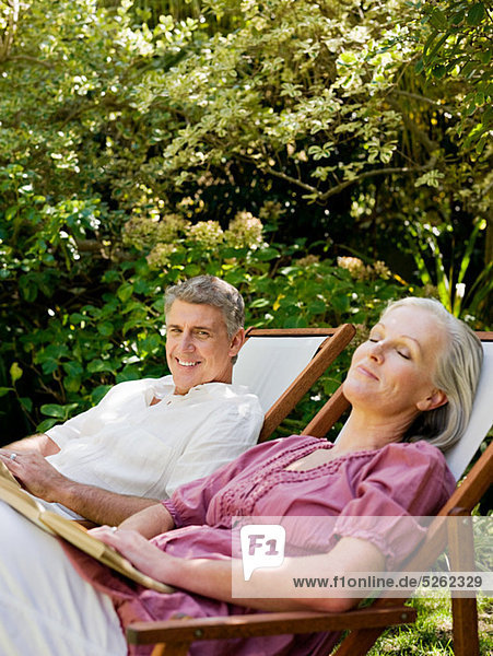 Couple sitting on deckchairs in garden