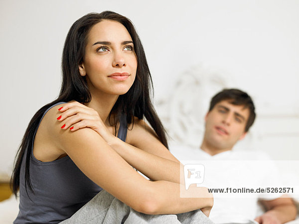 Young couple sitting on bed  focus on foreground