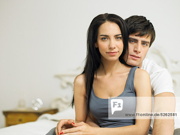 Young couple sitting on bed  portrait