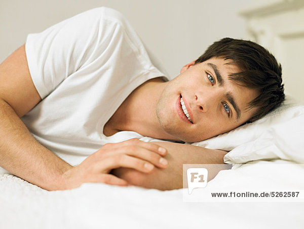 Young man lying on bed  portrait