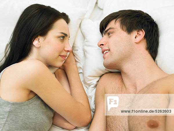 Junges Paar im Bett liegend von Angesicht zu Angesicht