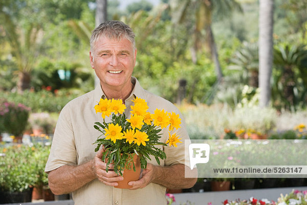 Senior Man mit Topfpflanze an Gartencenter
