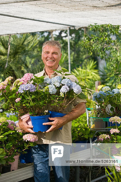 Senior Mann mit Topfpflanzen im Gartencenter
