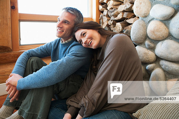 Mid adult couple sitting in log cabin