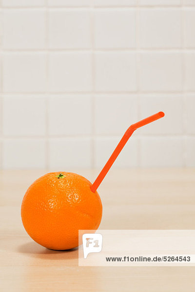 Orange mit trinken Stroh herausstrecken