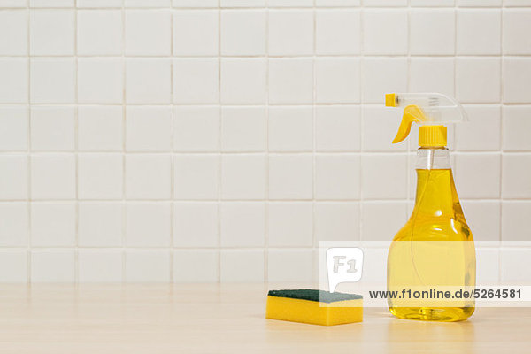 Flasche mit gelber Reinigungsflüssigkeit und Reinigungsschwamm