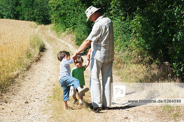 Großvater und Enkel zu Fuß auf ländliche Straße