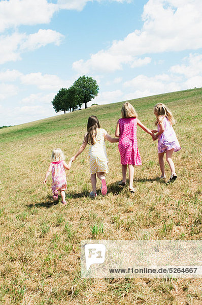 Four girls walking in field