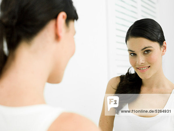 Reflexion der junge Frau im Badezimmerspiegel
