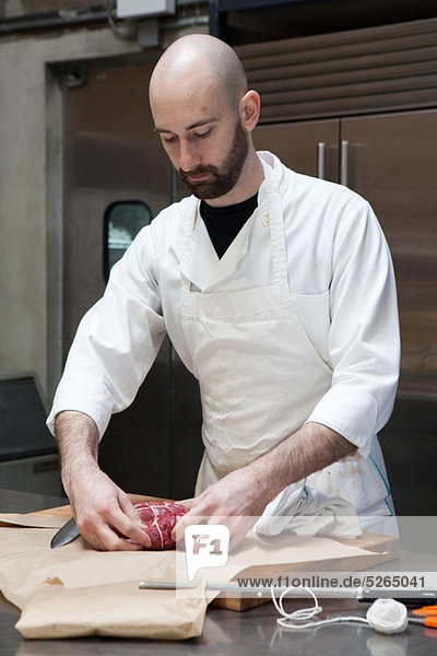 Butcher preparing beef tenderloin
