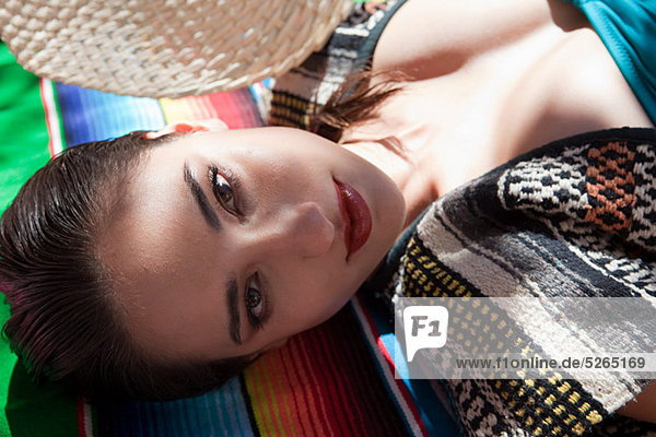 Woman lying on ethnic style blanket  close up