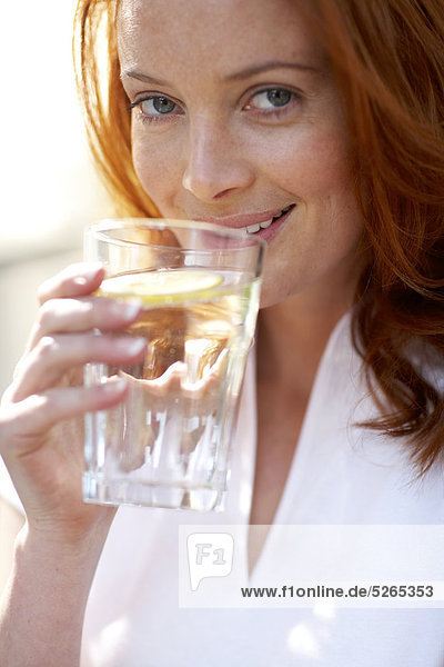 Mädchen mit rotem Haar zu gießen und Trinkwasser