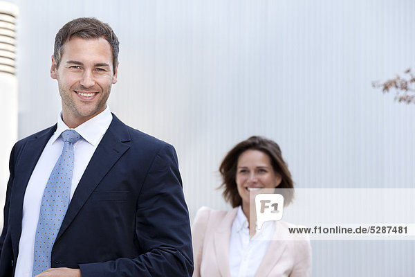 Smiling businessman and businesswoman outdoors