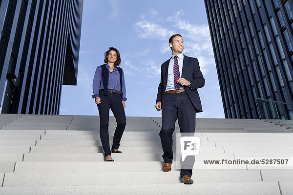 Geschäftsmann und Geschäftsfrau gehen auf einer Treppe