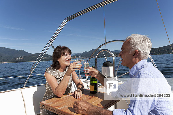 Älteres Paar mit Champagner auf dem Boot