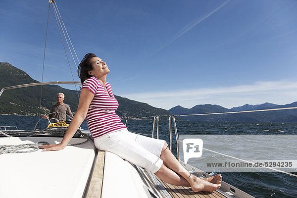 Older couple relaxing on sailboat