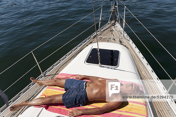 Older man relaxing on sailboat