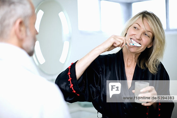 Frau beim Zähneputzen im Bad