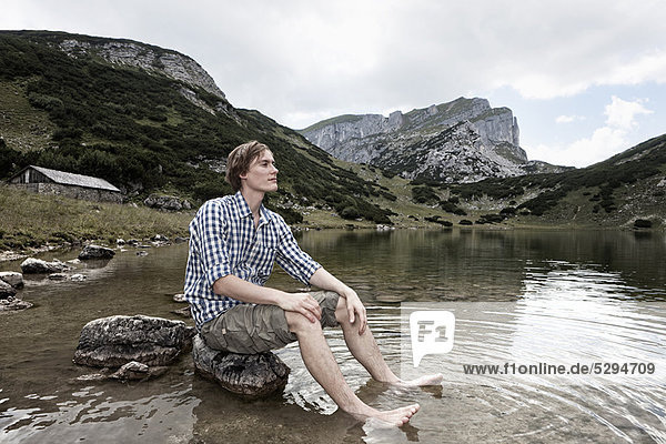 Man relaxing in rocky lake