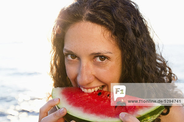 Lächelnde Frau isst Wassermelone