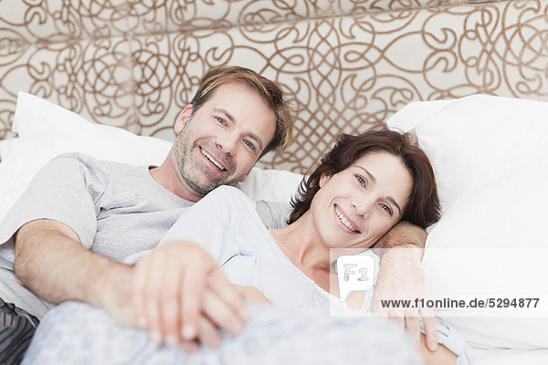 Smiling couple relaxing in bed