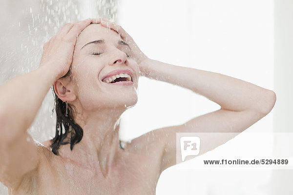 Lächelnde Frau beim Duschen