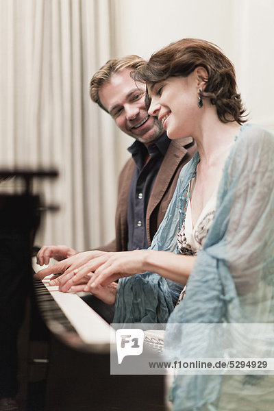Paare  die zu Hause zusammen Klavier spielen