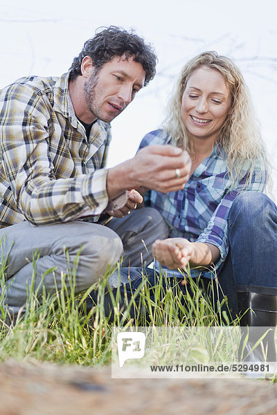 Couple examining seeds outdoors