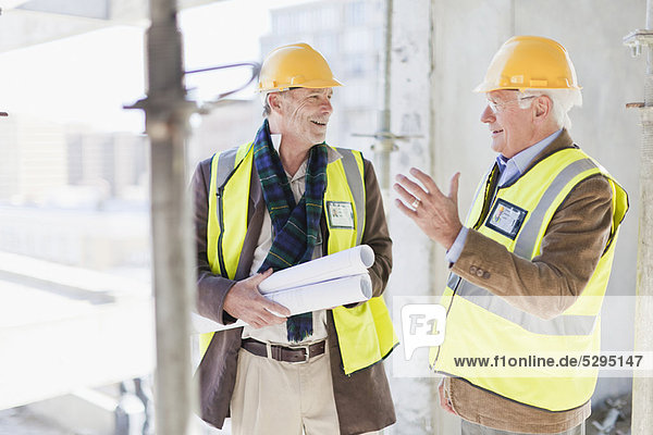 Businessman and worker talking on site