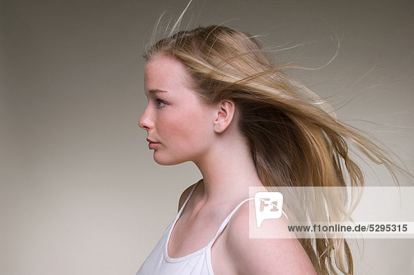 Teenage girl’s hair blowing in wind