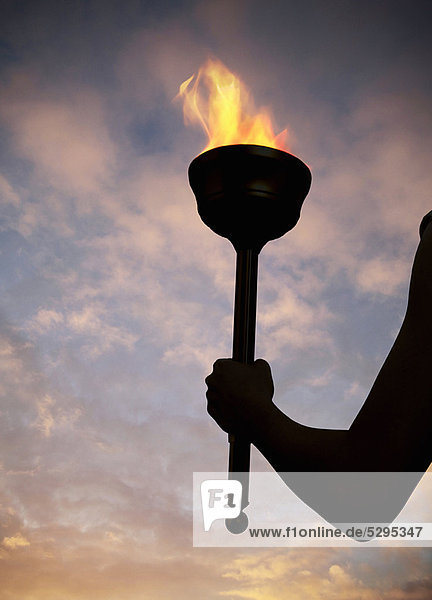 Hand holding flaming baton